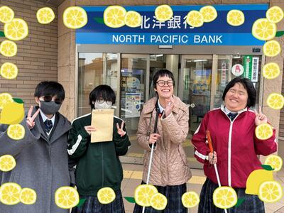 普通科3年1組の生徒が銀行の前で記念撮影。